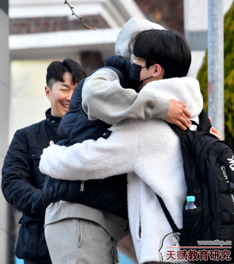 11月17日，韩国一处高考考场外，老师拥抱鼓励考生。（纽西斯通讯社）